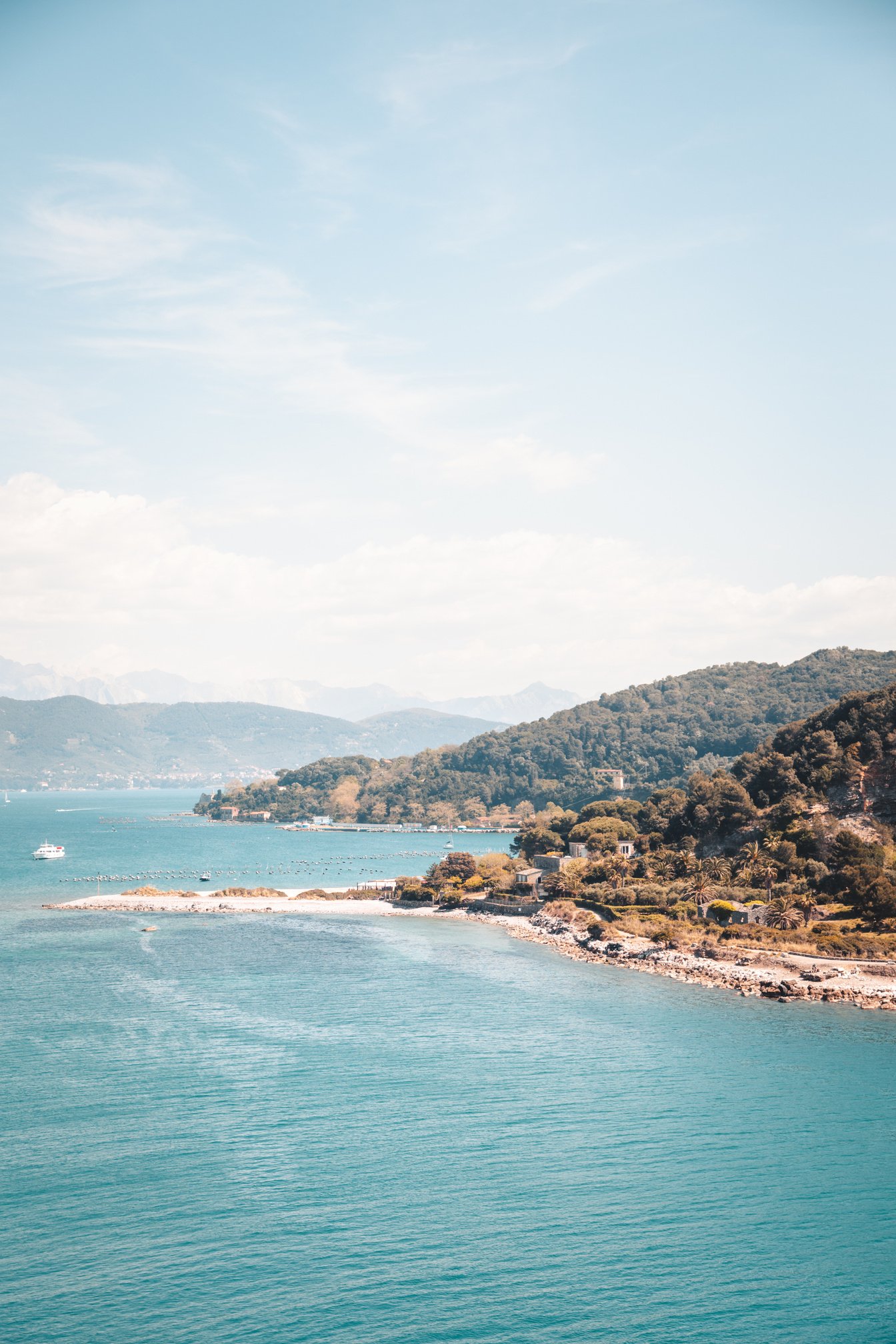 Green and Brown Mountains Beside Blue Sea Under Blue Sky